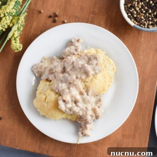 biscuits and sausage gravy on white plate.