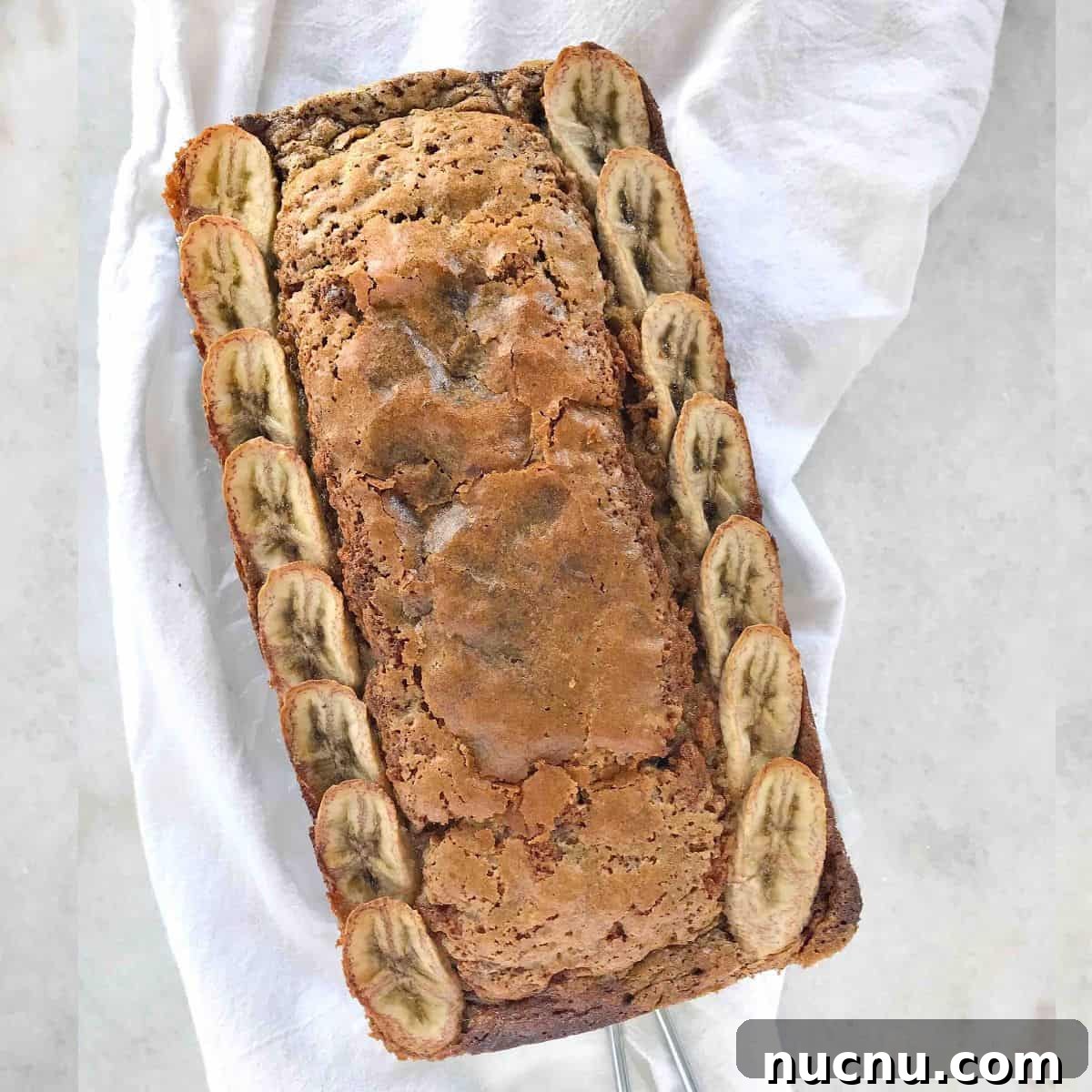 Moist Banana Bread Without Baking Soda: Simple Oven Recipe 8 loaf of banana bread with bananas shingled down sides.