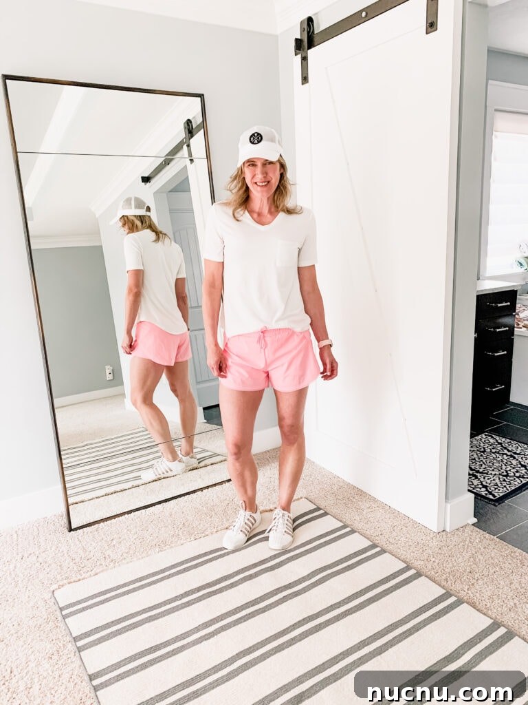 woman in pink shorts and white tee shirt with a hat on