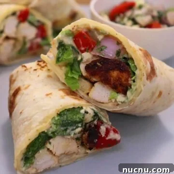 mediterranean chicken wrap. sliced and stacked over each other.