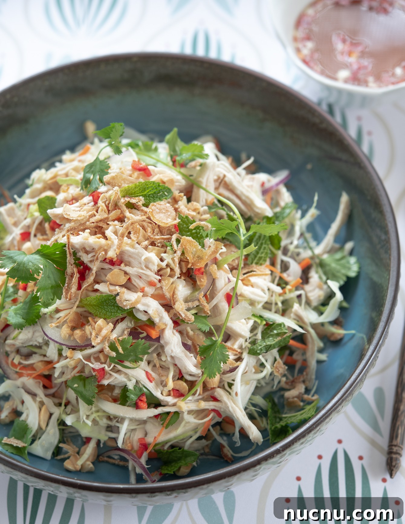 Authentic Vietnamese Shredded Chicken Salad (Gà Xé Phay) 12 A bowl of Vietnamese chicken salad served with fresh herbs and dressing