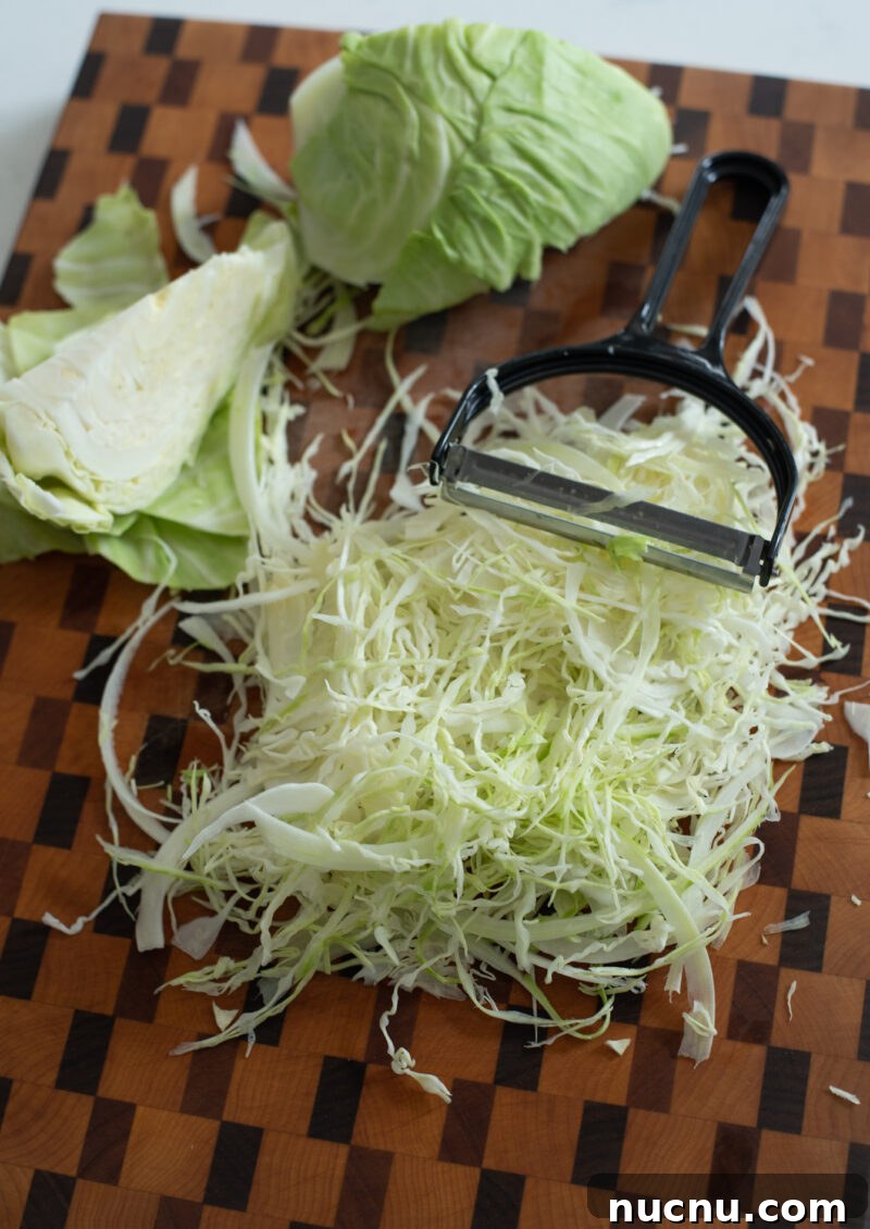 Authentic Vietnamese Shredded Chicken Salad (Gà Xé Phay) 8 Shredded green cabbage prepared with a vegetable peeler for salad prep.