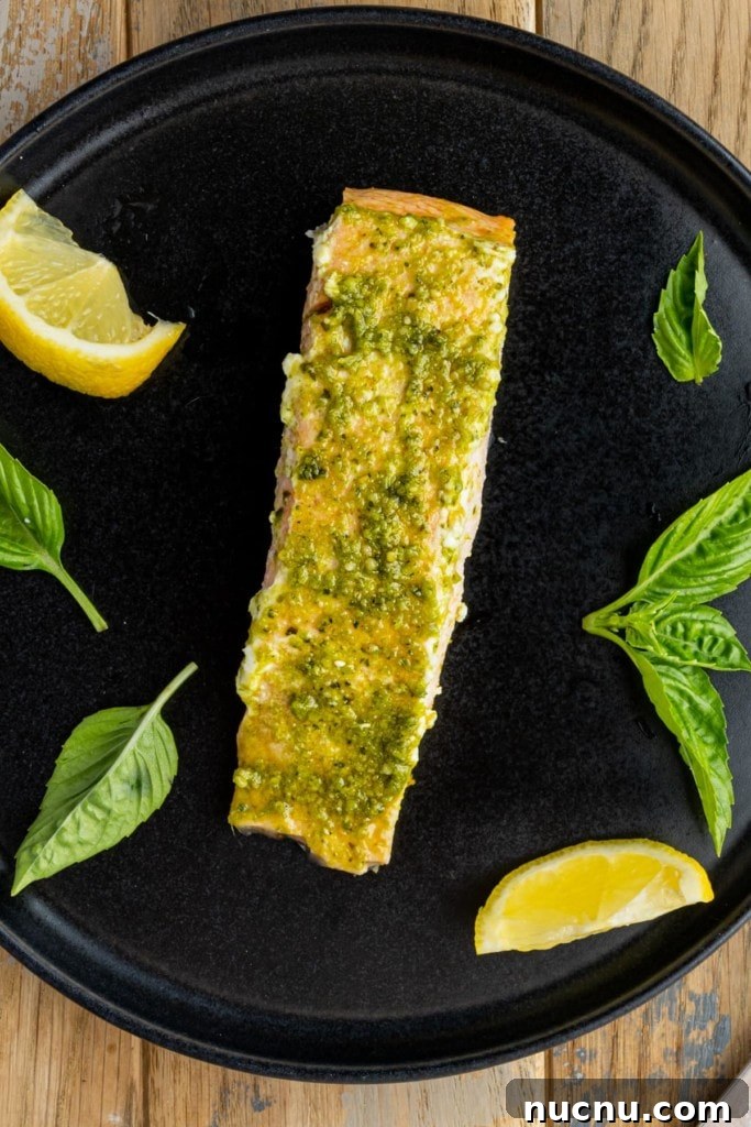 Pesto Butter Salmon with 3 Ingredients — Quick Weeknight Recipe 2 pesto butter salmon plated with basil and lemon wedges