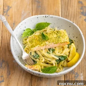 pesto butter salmon served on top of creamy pasta