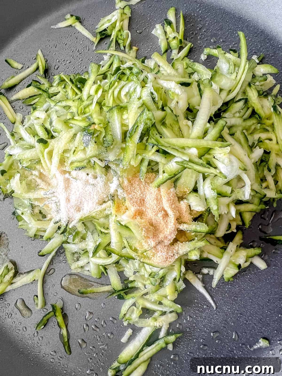 Zucchini Egg Muffin Cups: Protein-Packed Breakfast Bites 5 Shredded zucchini in a pan with spices.