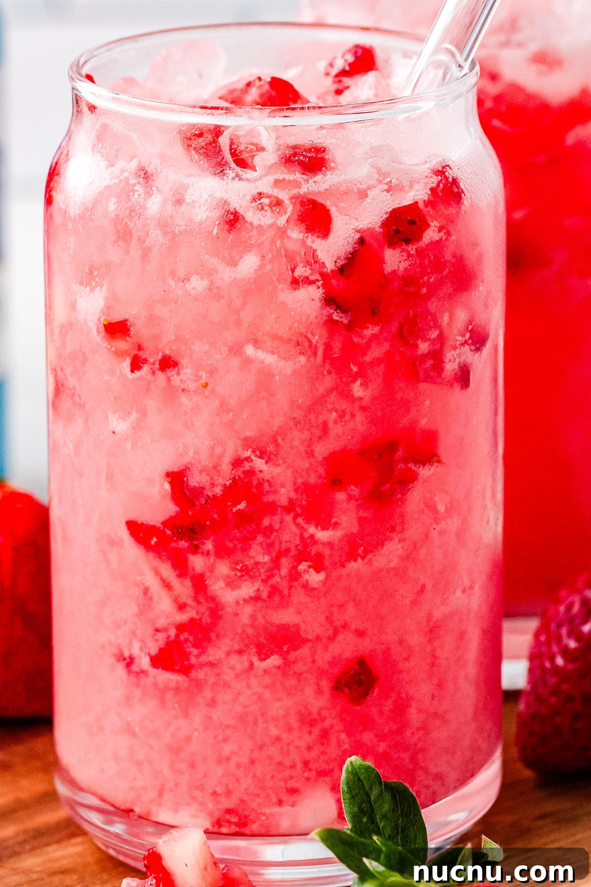 Strawberry Breeze Cocktail Copycat Recipe: Refreshing Homemade Drink 2 A strawberry breeze in a clear drinking glass with pebble ice and a drinking straw.