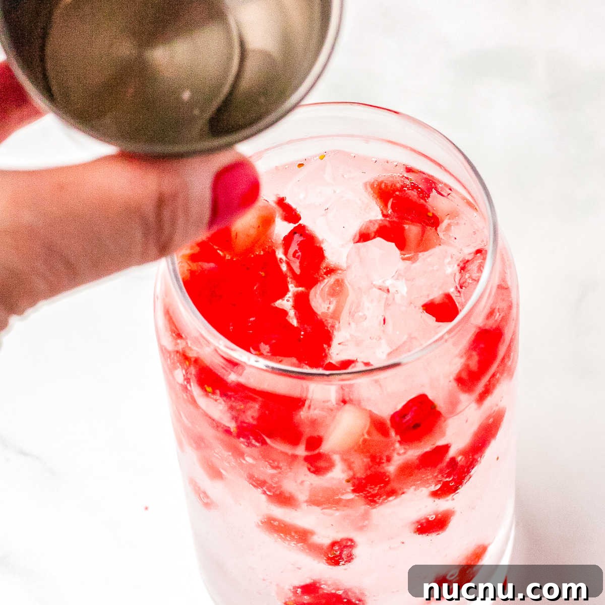 Strawberry Breeze Cocktail Copycat Recipe: Refreshing Homemade Drink 7 Vanilla and coconut syrup being poured into the glasses.