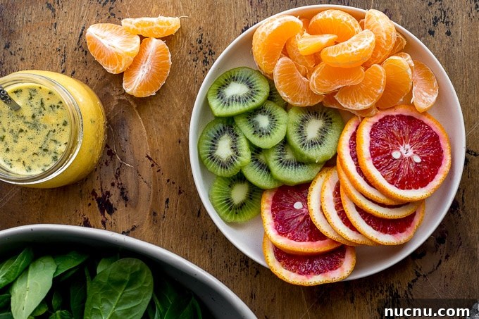 Winter Citrus Salad with Honey Dressing and Toasted Almonds 5 Sliced kiwis and oranges arranged on a plate.