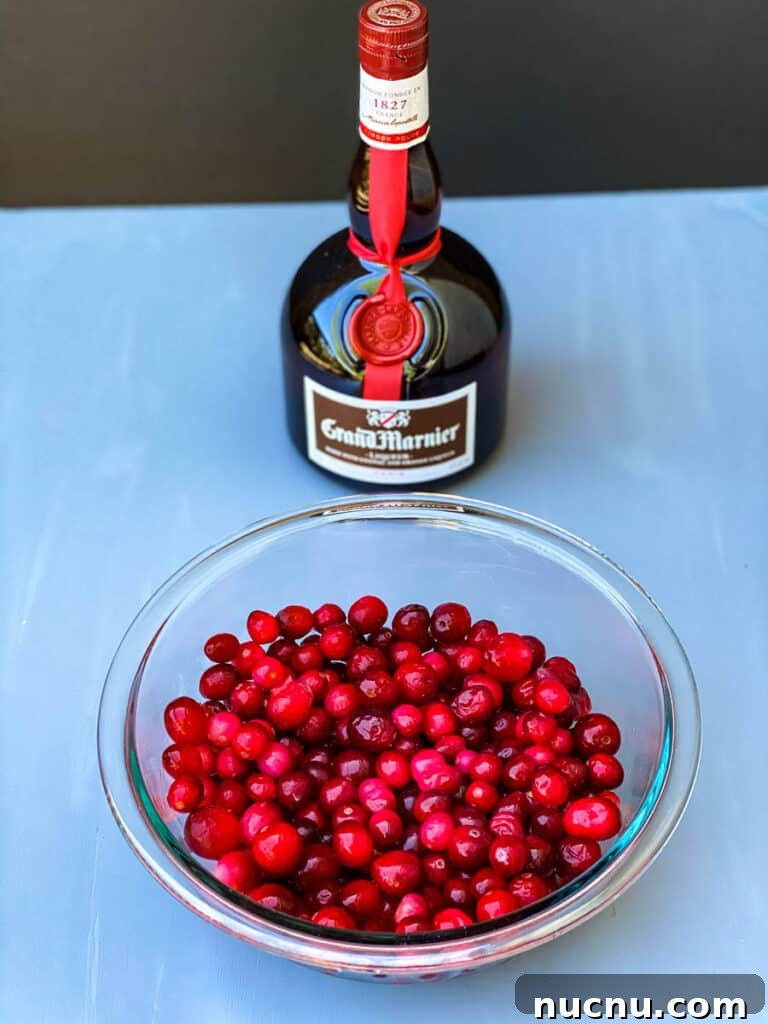 Grand Marnier Cranberry Sauce Recipe for Holiday Dinners 4 fresh or frozen cranberries in a glass bowl along with a bottle of Grand Marnier