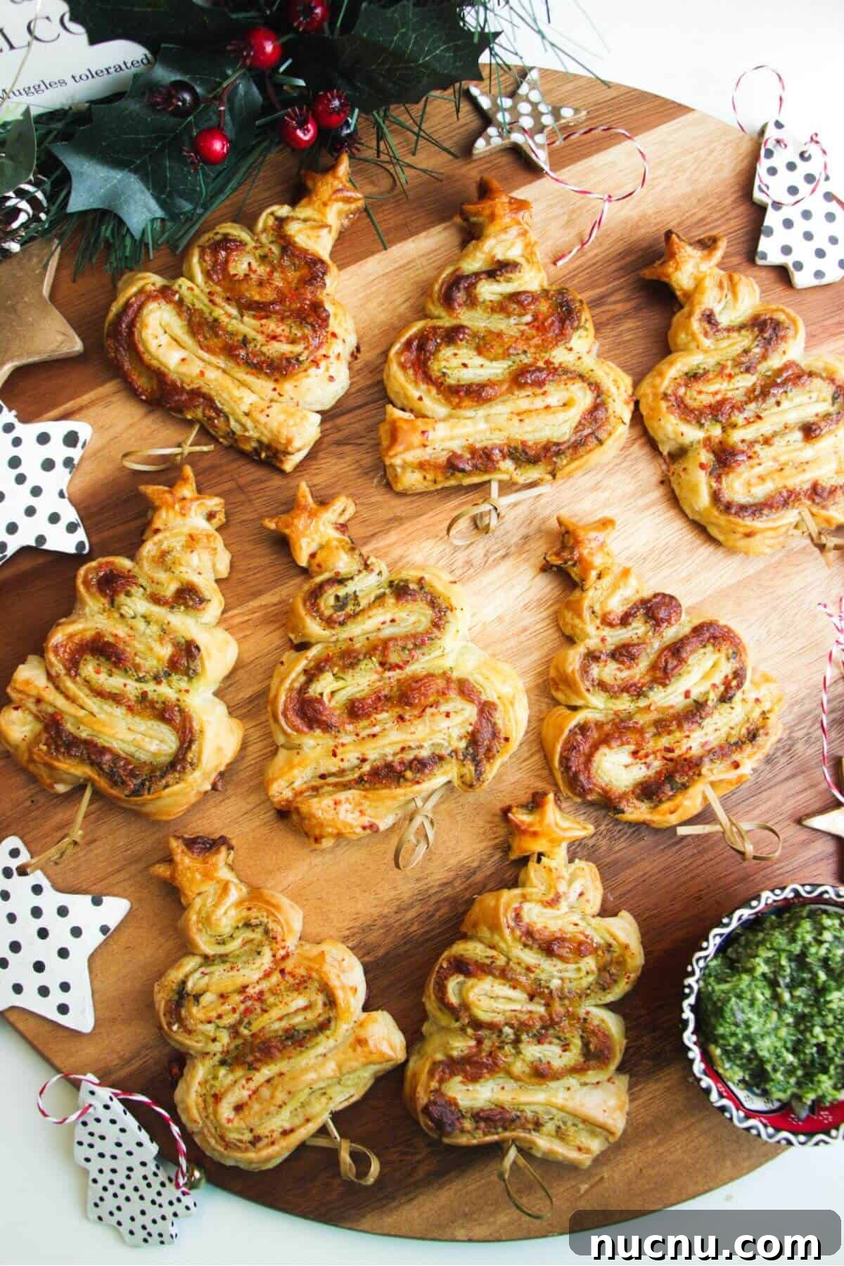Pesto puff pastry Christmas trees on a wooden board.