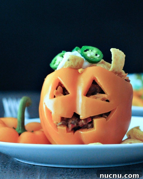 Frito Pie Stuffed Peppers a bell pepper carved into a halloween jack o lantern, filled with Frito pie (chili and fritos)