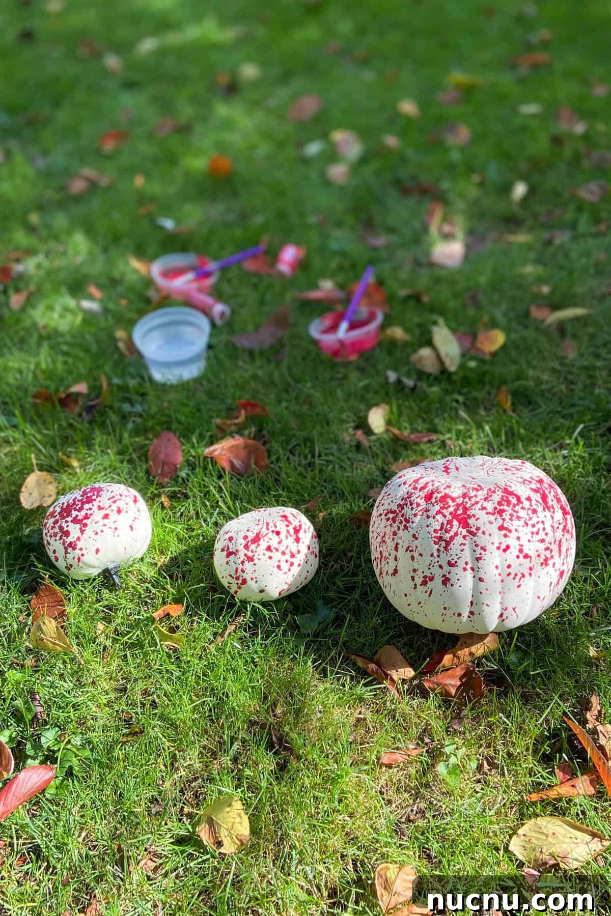 Painting pumpkins in the grass.