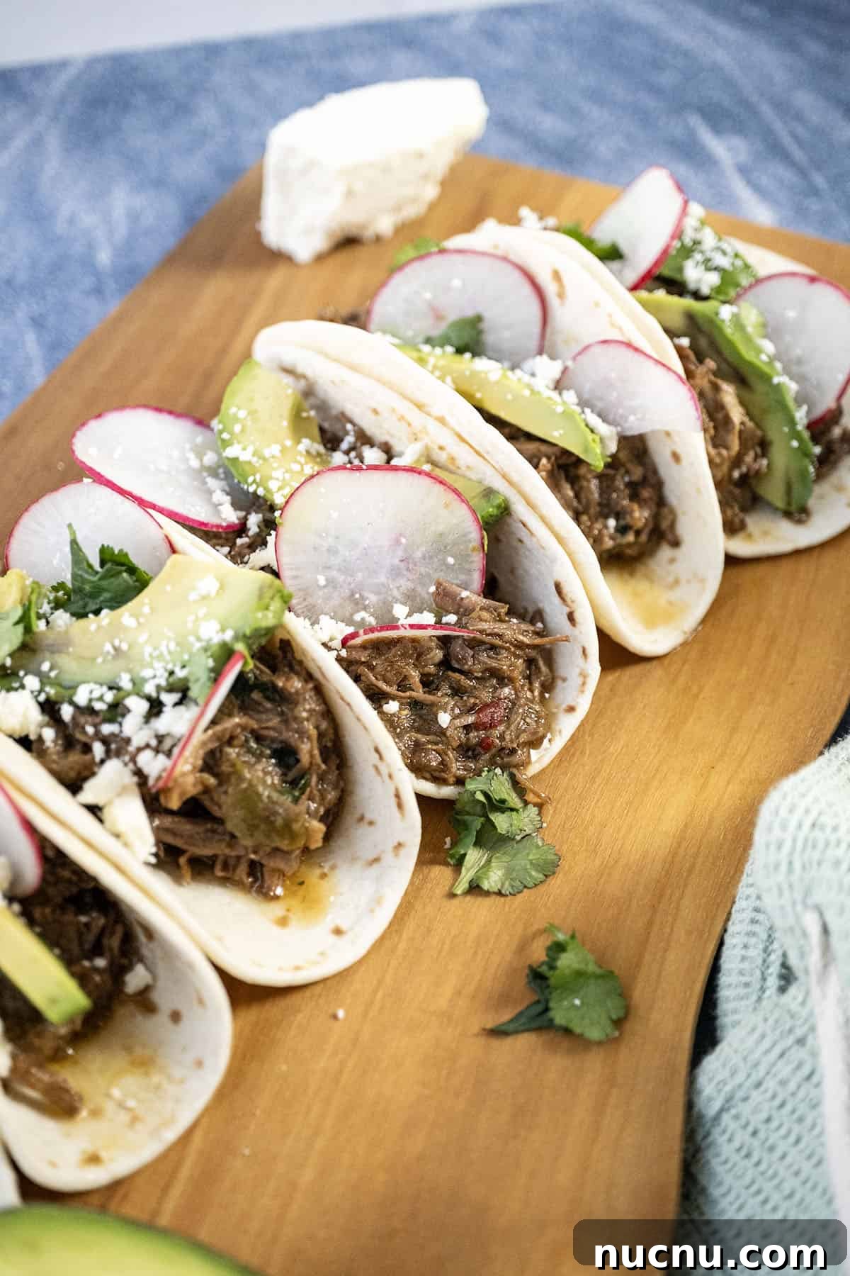 Dutch Oven Barbacoa Tacos Recipe — Tender Slow-Cooked Beef Tacos 9 Beef barbacoa tacos with sliced radish, avocado, and cotija cheese.