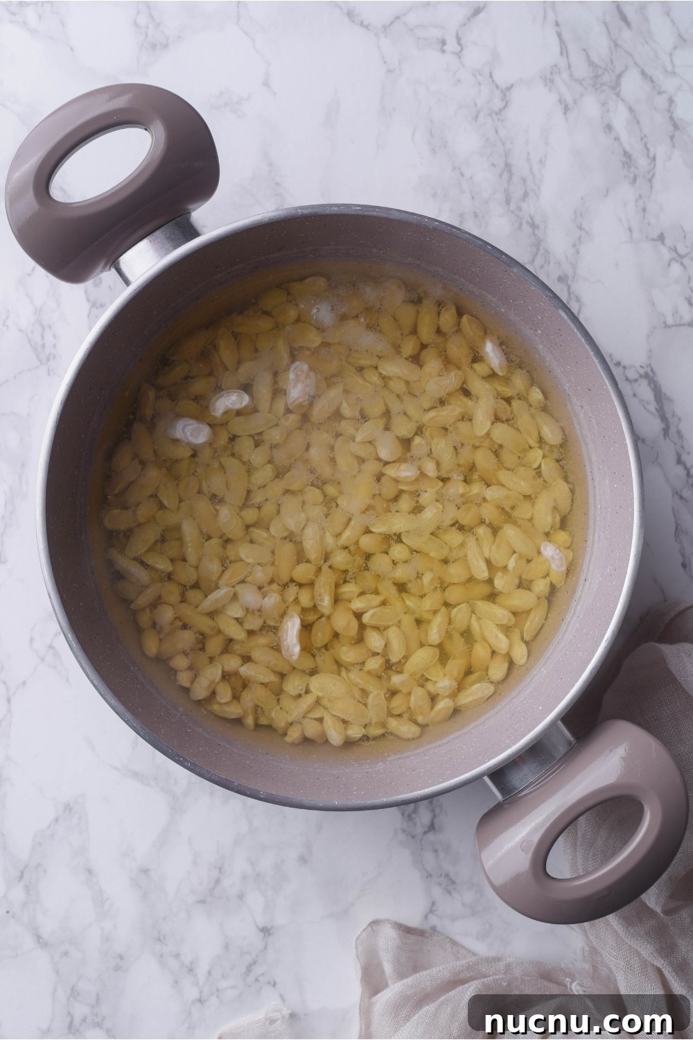 Copycat Grandma Brown's Baked Beans Recipe You’ll Love 6 A grey pot filled with dried beans soaking in seasoned water.