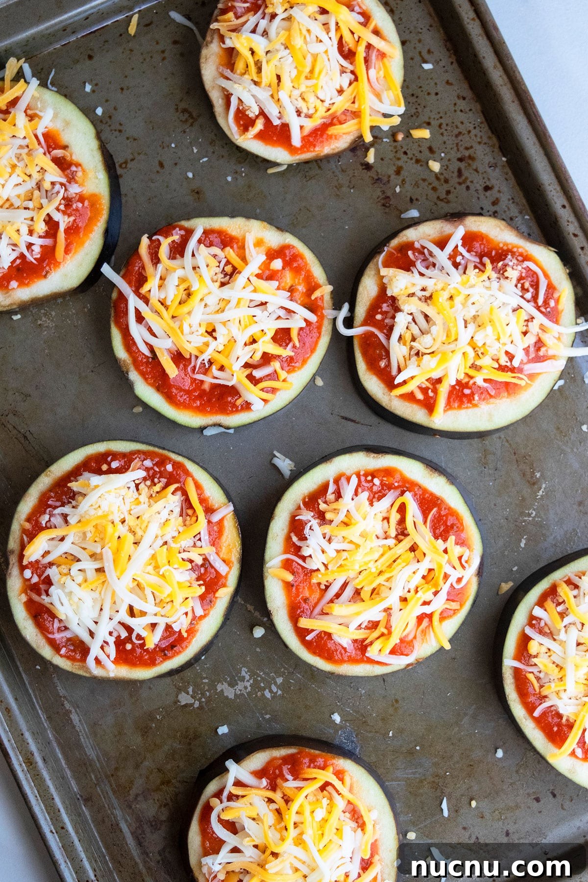 One-Pan Eggplant Pizza Recipe for Quick Weeknight Meals 4 Unbaked low carb pizzas on baking tray.