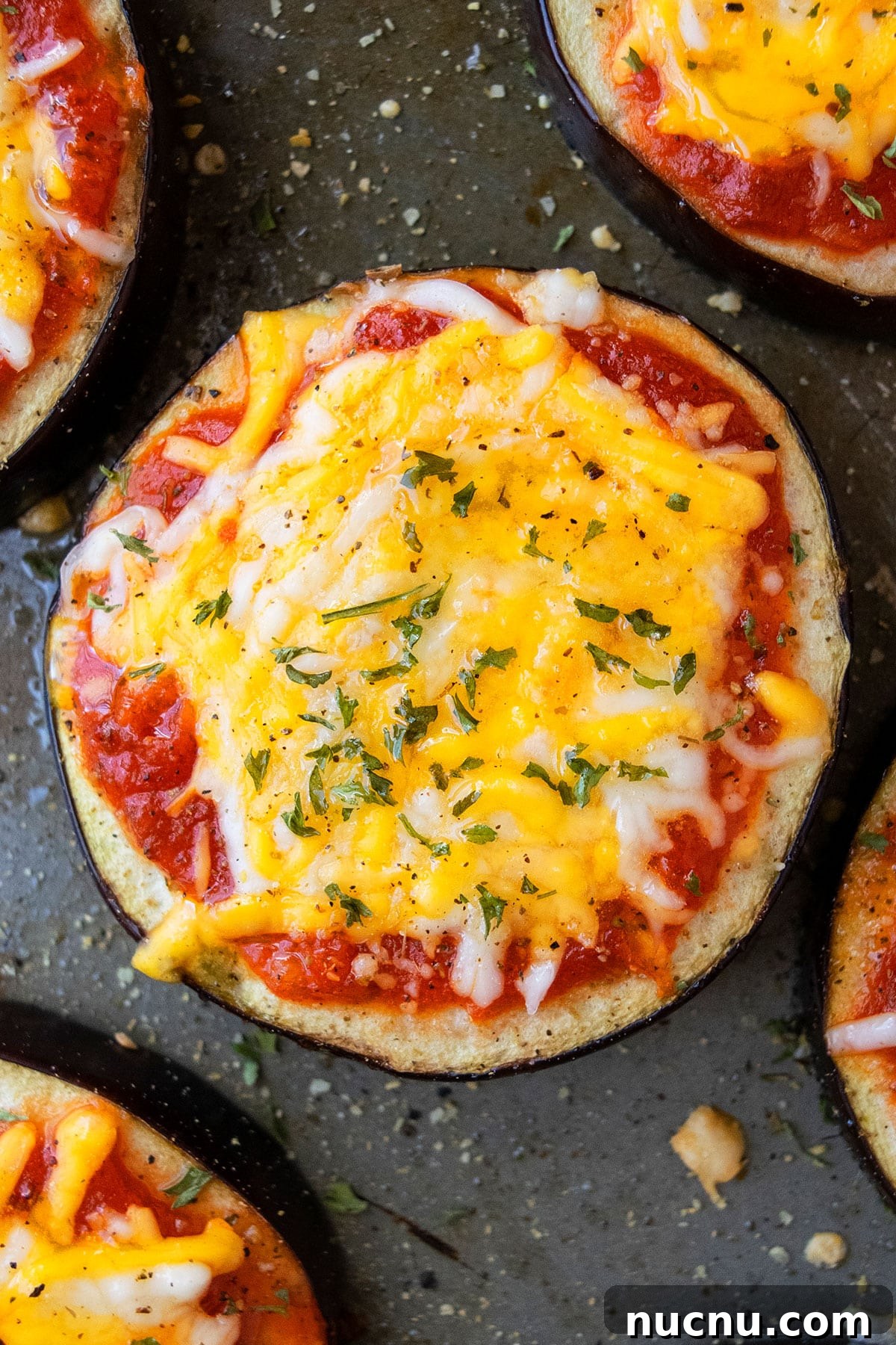 One-Pan Eggplant Pizza Recipe for Quick Weeknight Meals 6 Aubergine pizza with cheese on baking tray- Overhead shot.