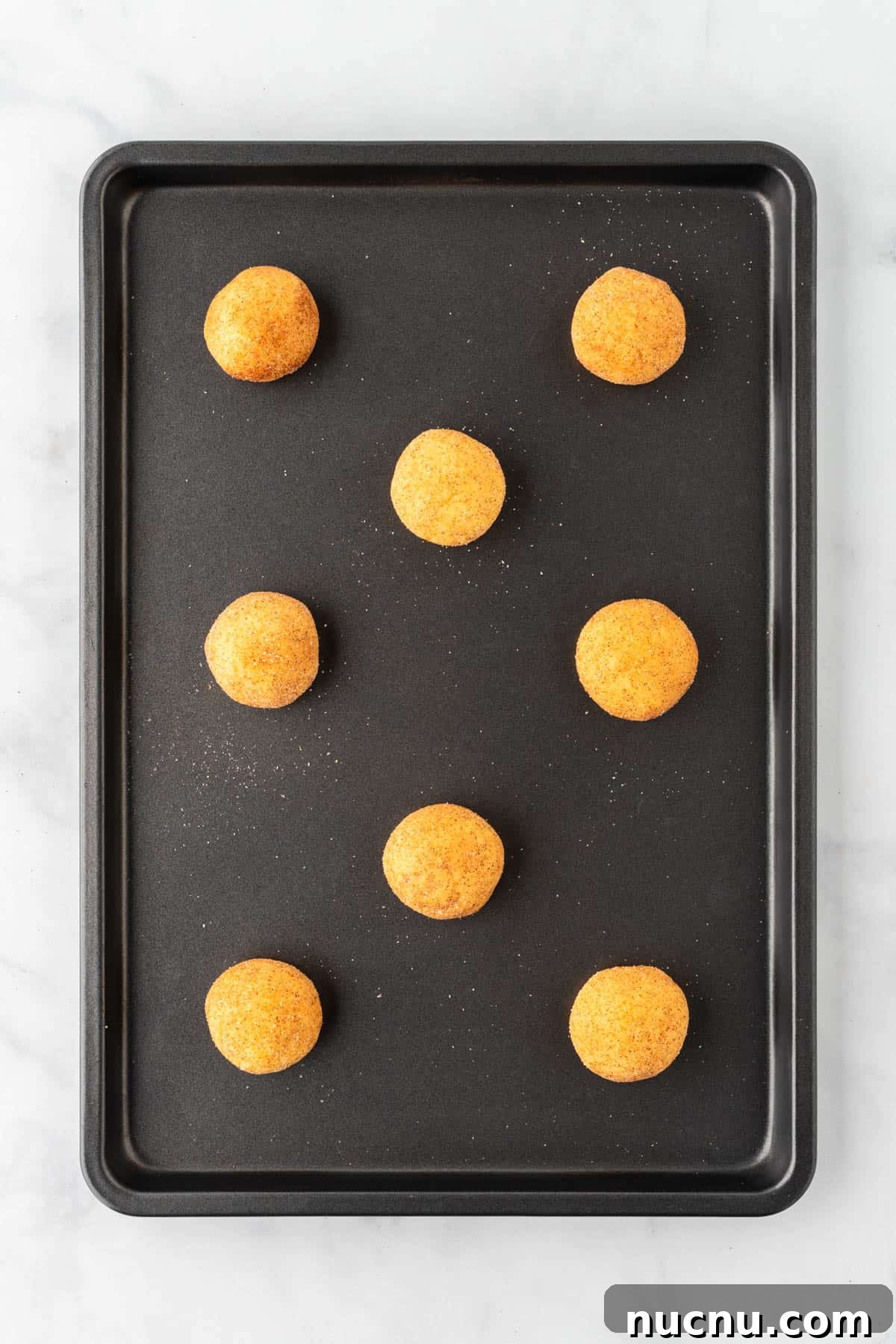 cookie dough in balls on a baking sheet