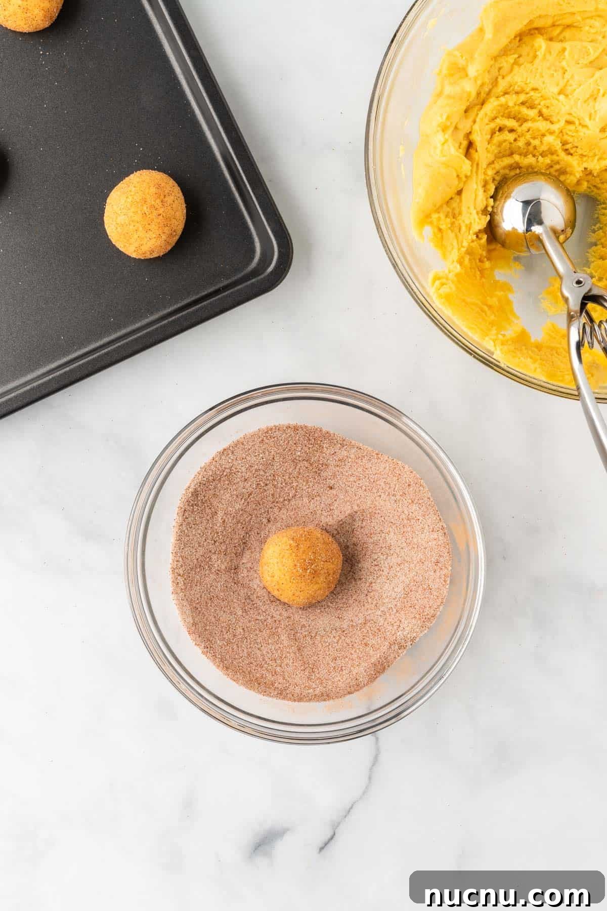 rolling a ball of dough in cinnamon sugar topping