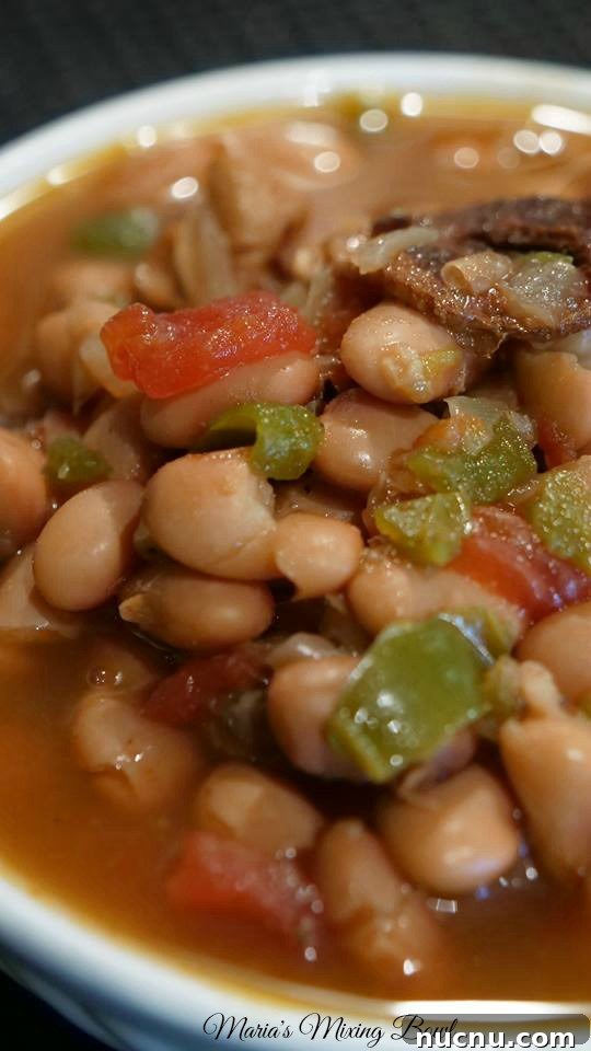Slow Cooker Spicy Pinto Beans Recipe — Tender, Flavorful & Simple 9 close up view of pinto beans, peppers, tomatoes, and bacon in a slow cooker all cooked up