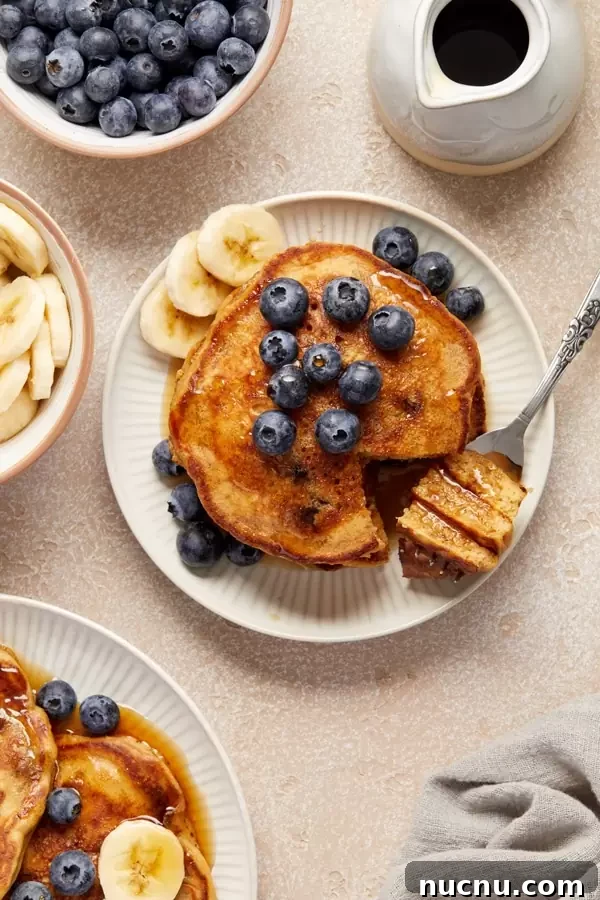 Several Fluffy Oat Milk Pancakes on a plate with a bite taken out.