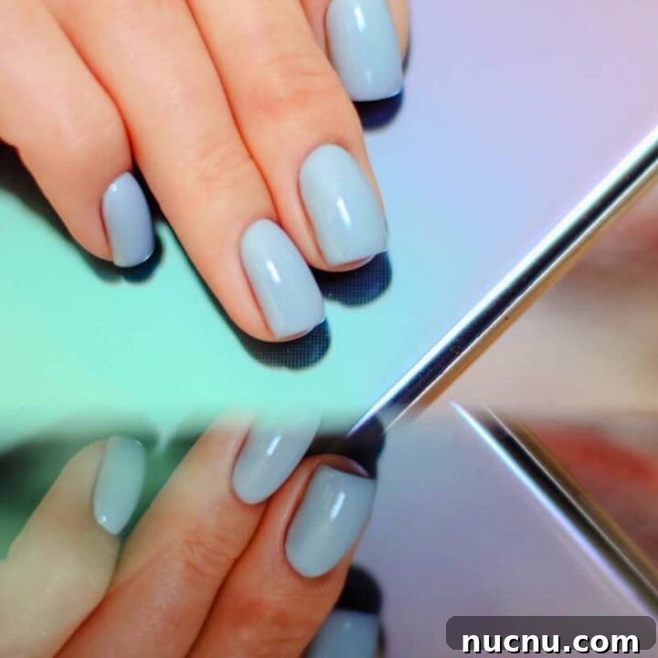 teal blue acrylic nails hands holding phone.