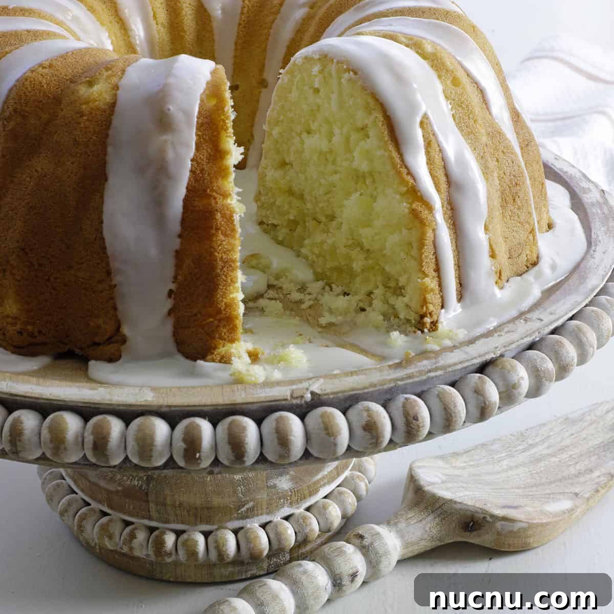 Baked cake on wooden cake pedestal with matching cake server.
