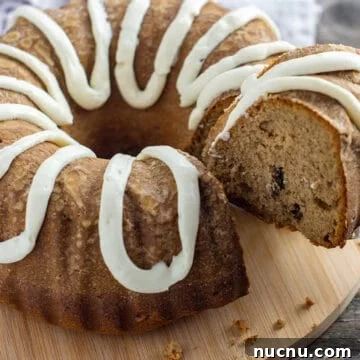 baked cake with one slice on round wooden cake holder being removed with cake spatula