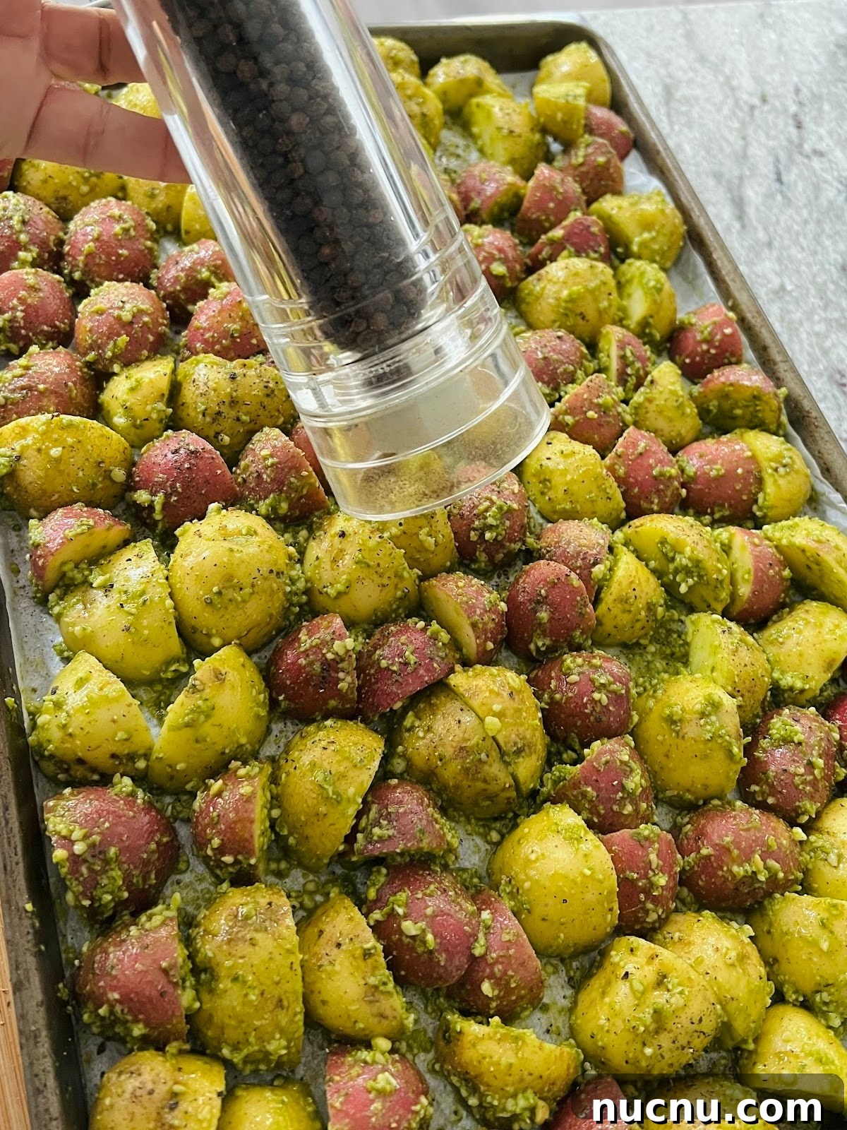 Crispy Pesto-Roasted Potatoes with Garlic and Parmesan 10 Pesto Potatoes on Sheet Pan with Black Pepper.