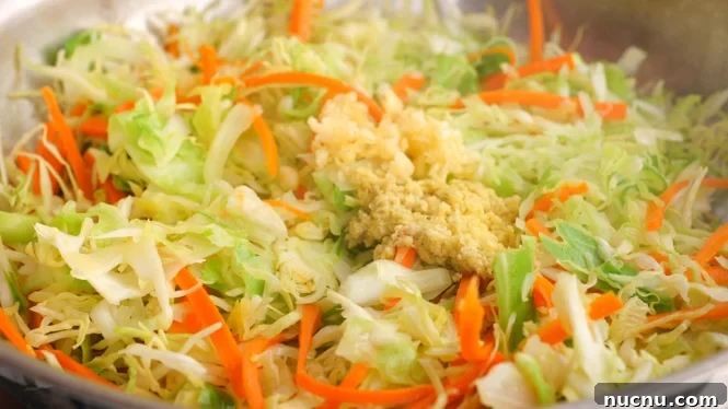 Deconstructed Egg Roll Bowl: Quick Pork and Cabbage Stir-Fry 3 sautéing ginger, garlic and vegetables in a skillet