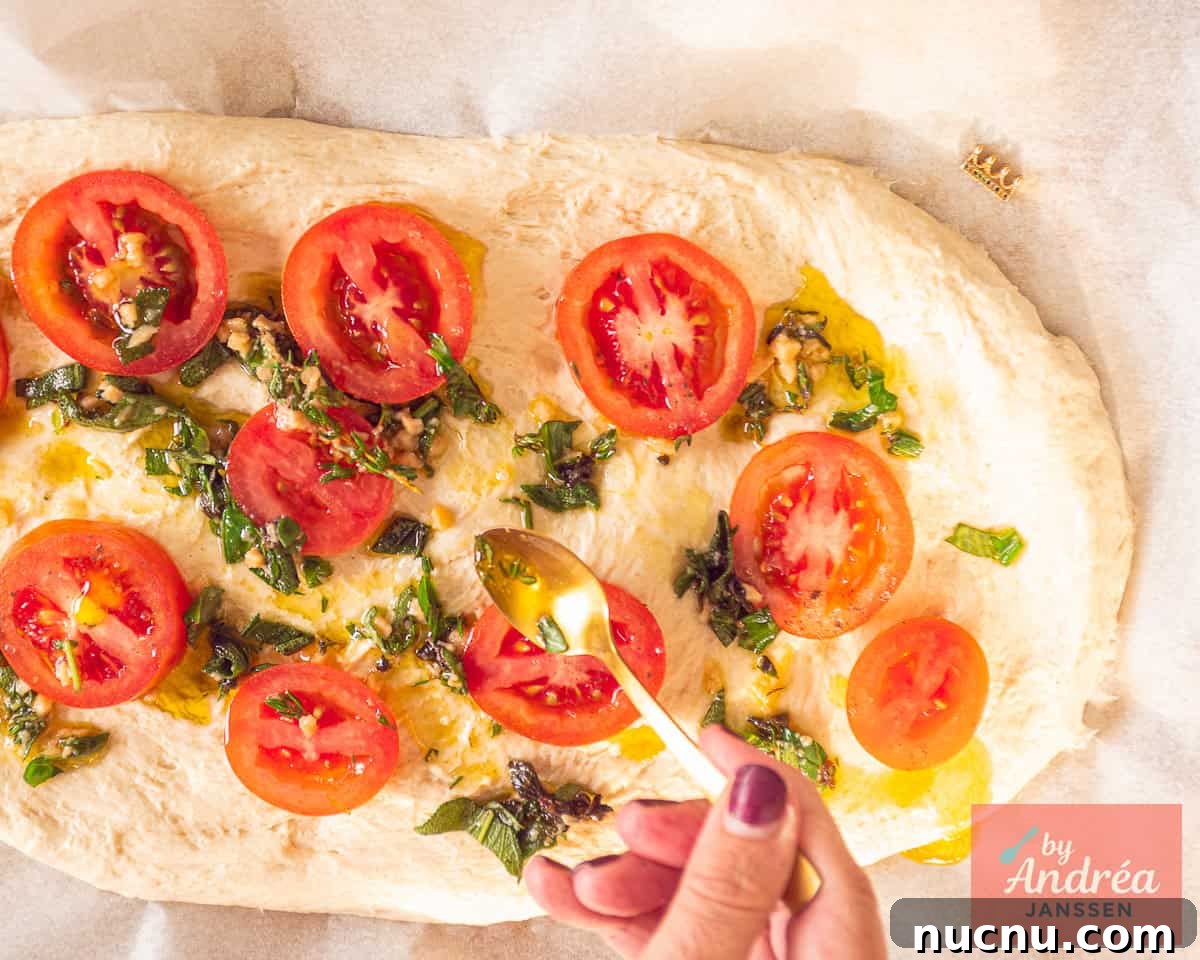 Crispy-Edged Tomato Focaccia with Parmesan and Olive Oil 6 The top of the bread is topped with slices of tomato and a herb oil.