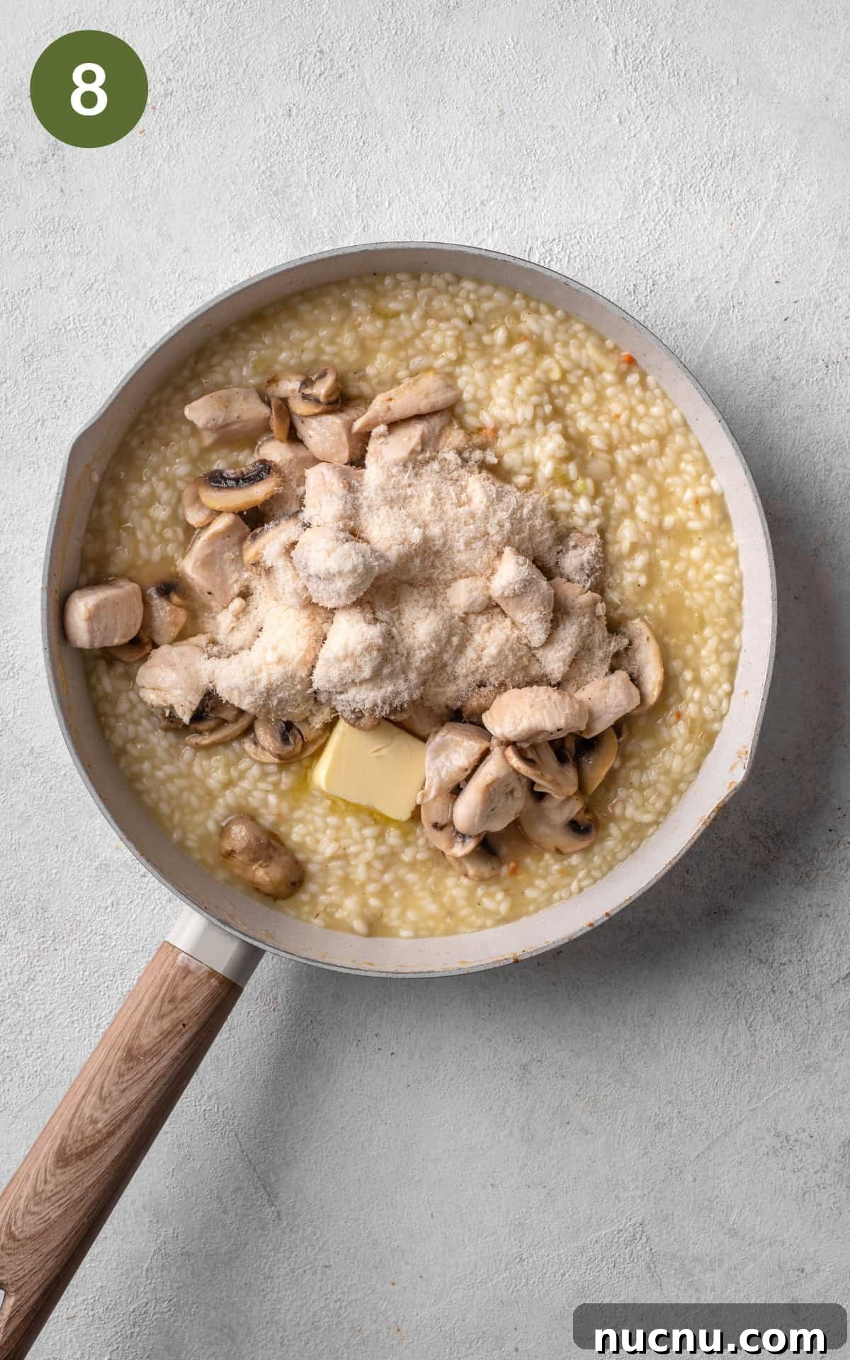 Creamy Chicken and Mushroom Risotto Recipe for Weeknight Dinner 11 rice, chicken, and parmesan mixed in a skillet.