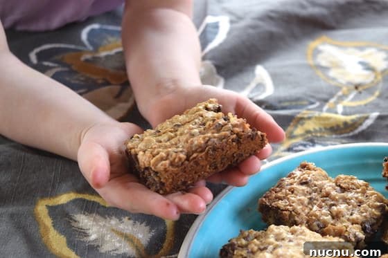 toddler holding homemade oatmeal bars with chocolate chips