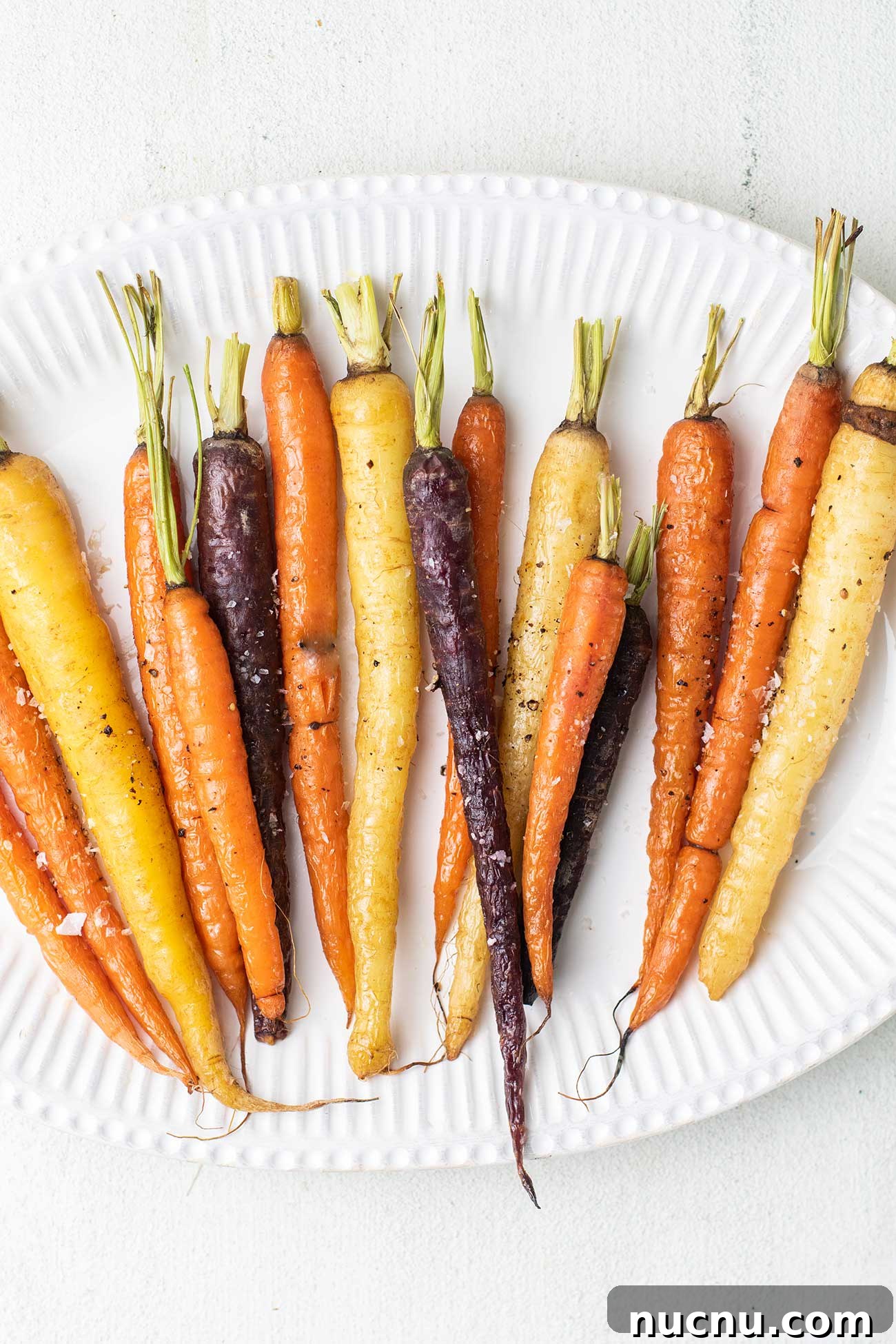 Roasted Rainbow Carrots with Garlic and Fresh Thyme 2 A white platter with roasted rainbow carrots ready to serve.