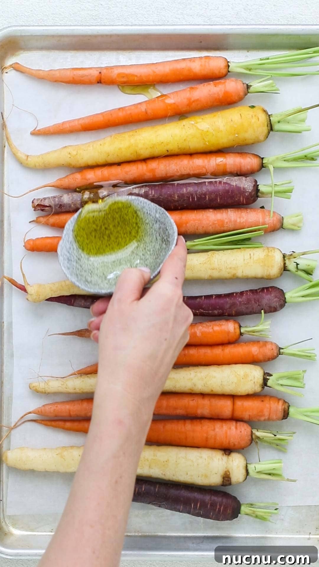 Roasted Rainbow Carrots with Garlic and Fresh Thyme 4 Olive oil being drizzled on rainbow carrots.