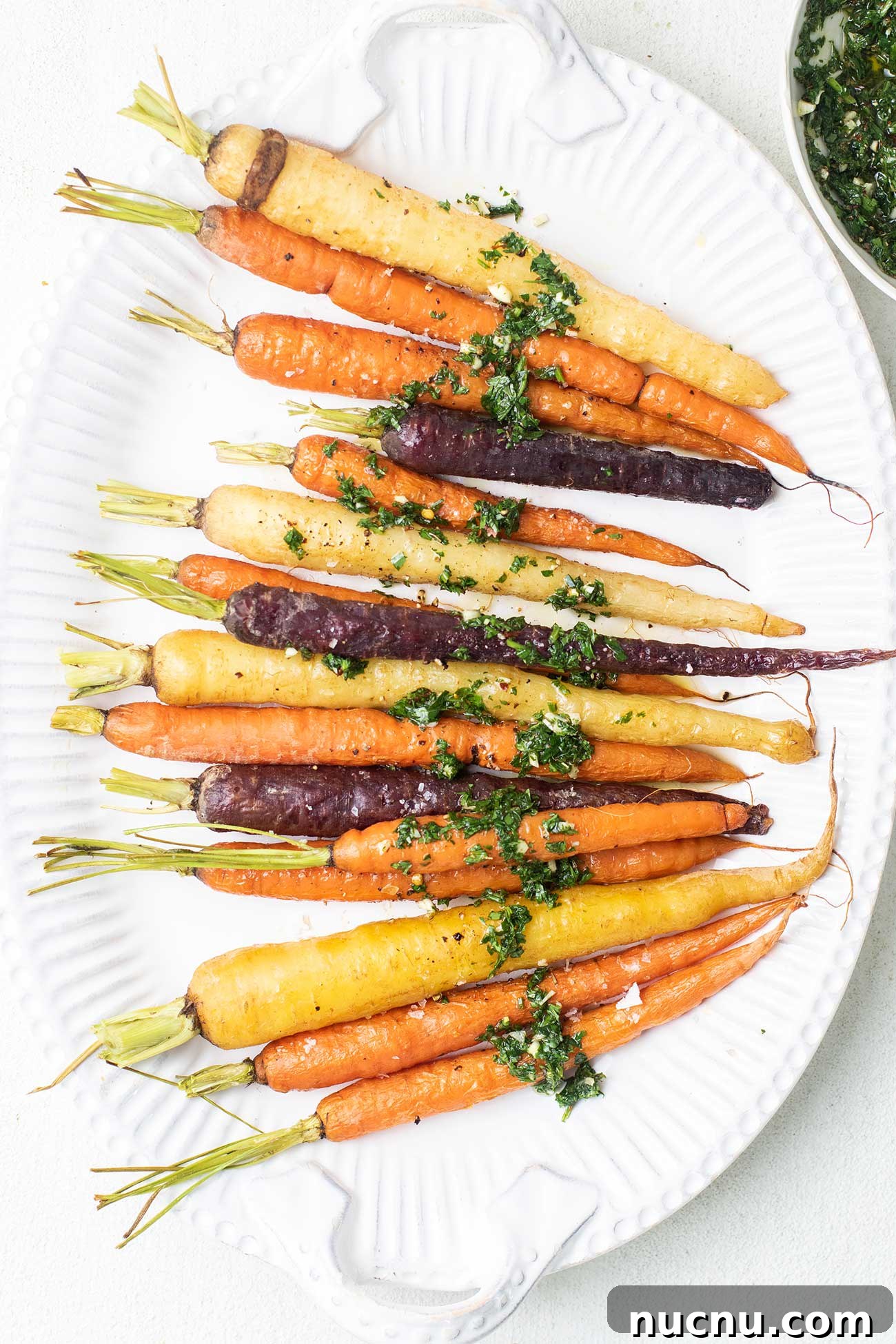 Roasted Rainbow Carrots with Garlic and Fresh Thyme 7 Roasted rainbow carrots shown drizzled with an herby chimichurri.
