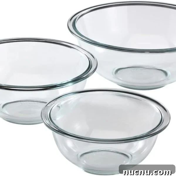 Three clear glass mixing bowls of different sizes are arranged on a white background. Each bowl has a rounded shape and a slightly flared rim.