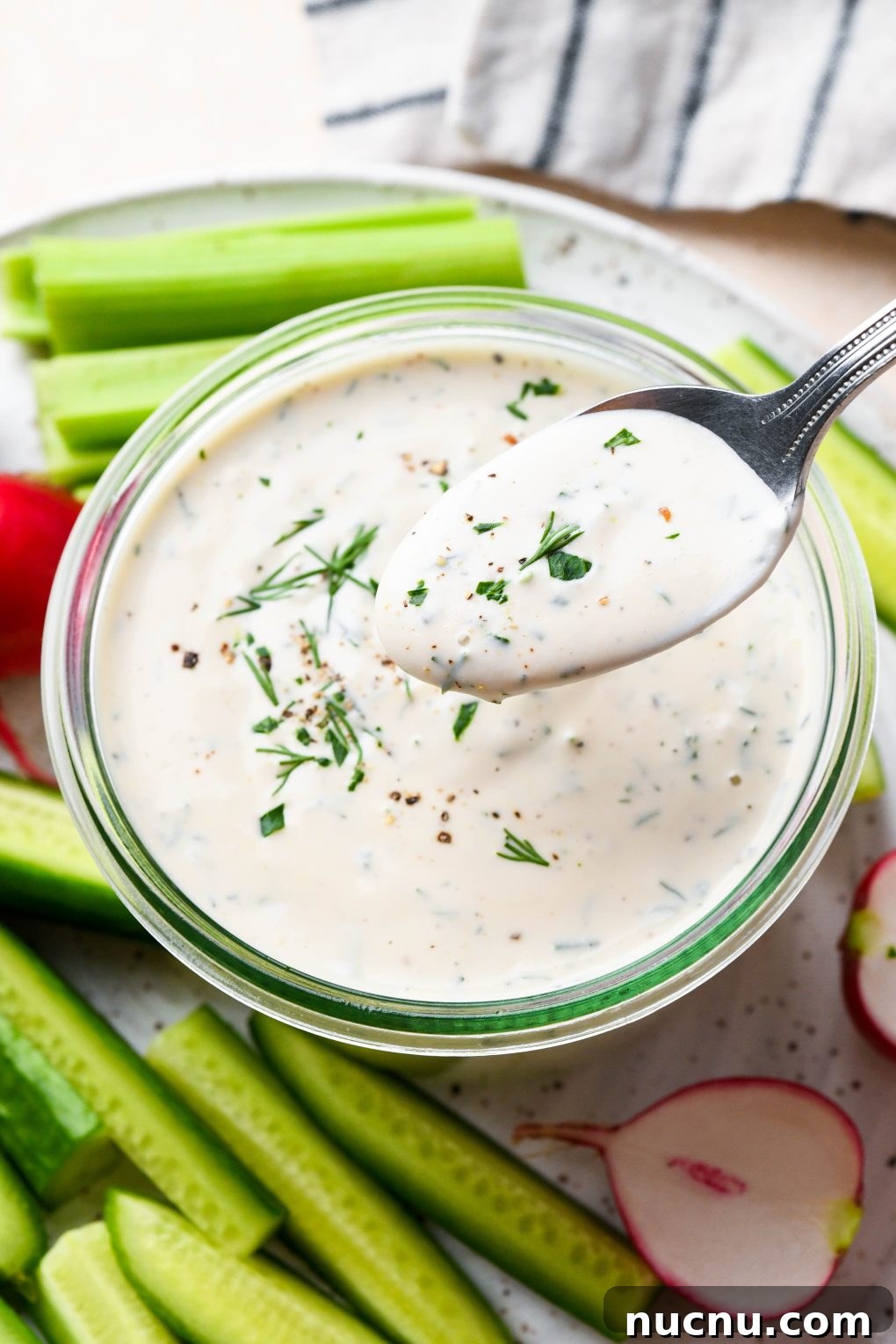Creamy Raw Cashew Vegan Ranch Dressing Recipe 3 Vegan ranch in a small glass jar with a spoon lifting some of the dressing out to show the creamy texture.