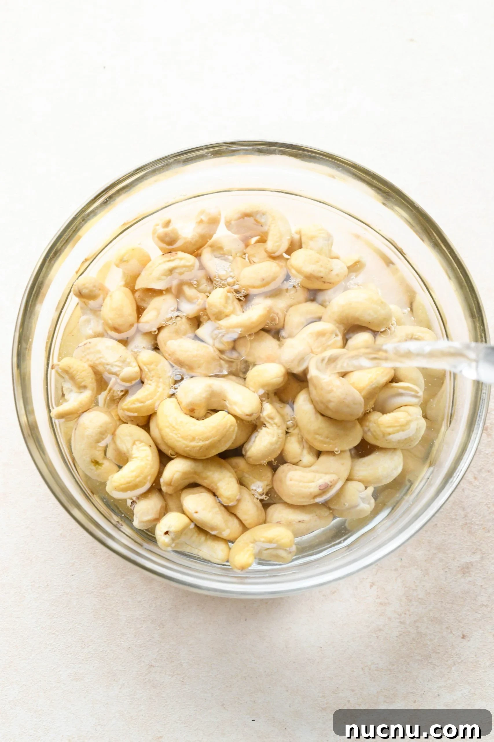 Creamy Raw Cashew Vegan Ranch Dressing Recipe 5 How to make vegan ranch dressing: Pouring hot water over raw cashews in a glass bowl.