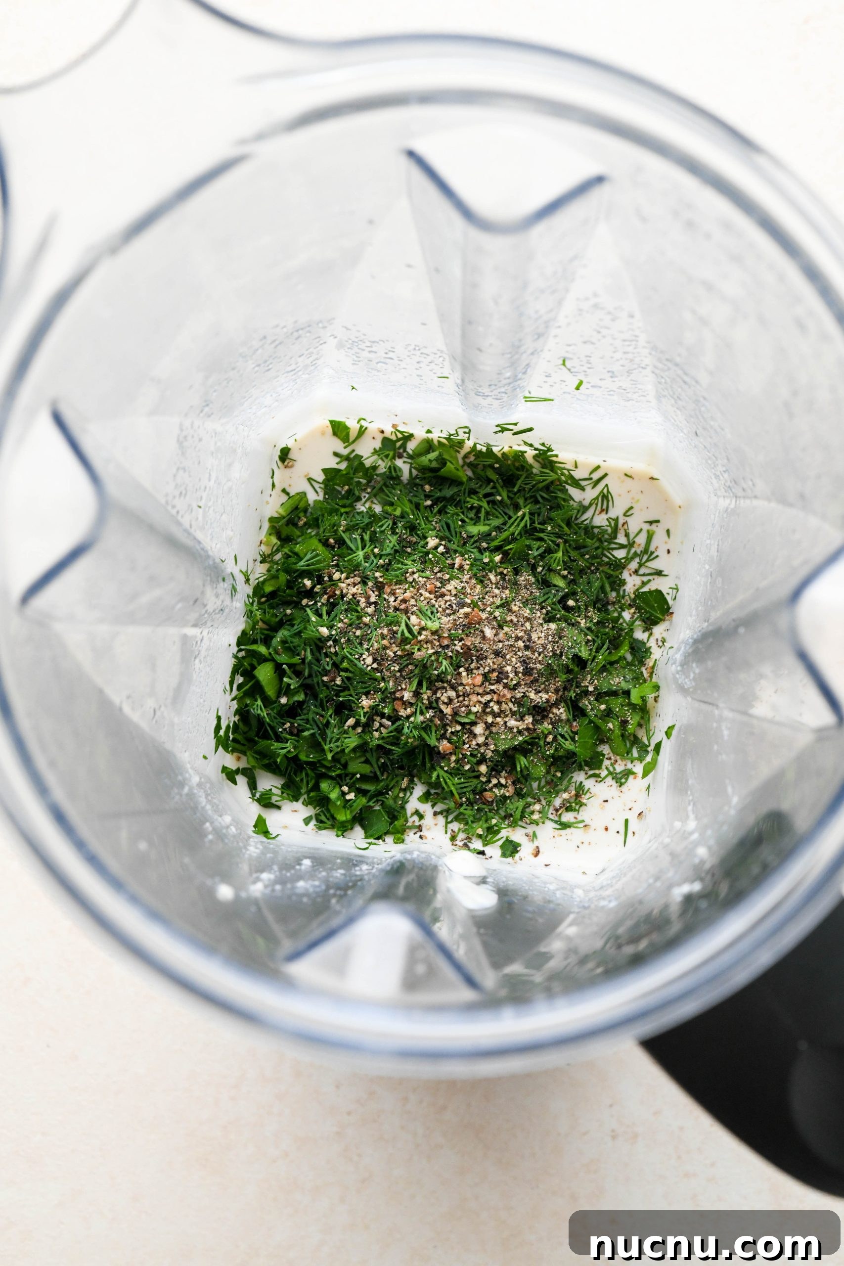 Creamy Raw Cashew Vegan Ranch Dressing Recipe 8 How to make vegan ranch dressing: Herbs and black pepper added to the blended cashews in blender container.