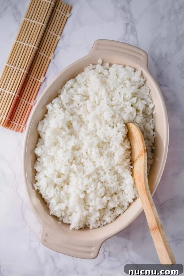 Perfect Sushi Rice: Step-by-Step Guide for Authentic Results 2 sushi rice serve in a dish with a wooden spoon