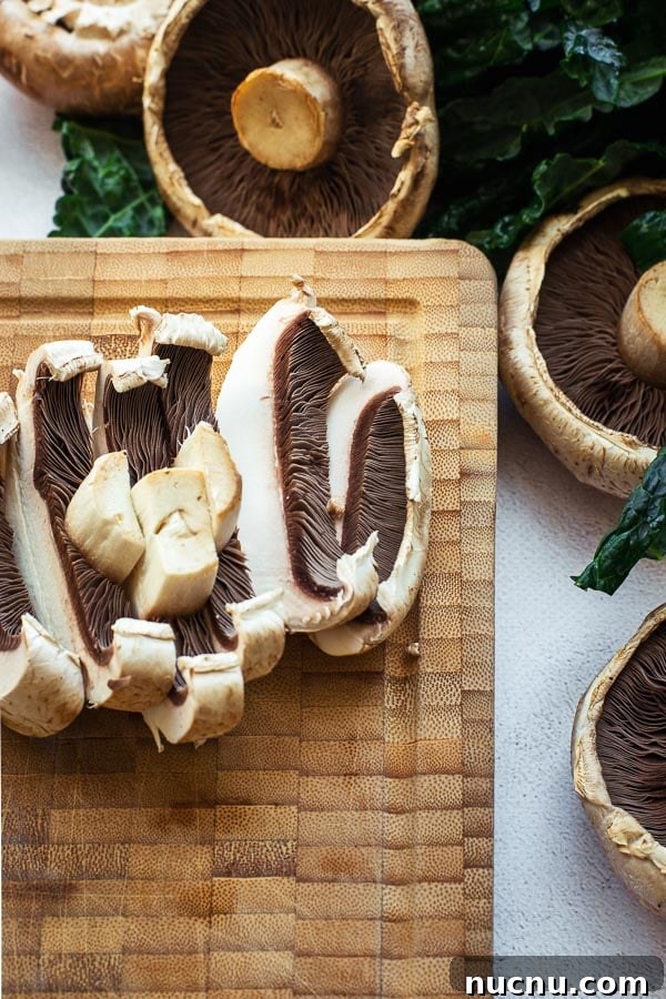 Sliced portobello mushrooms on a bamboo chopping board.