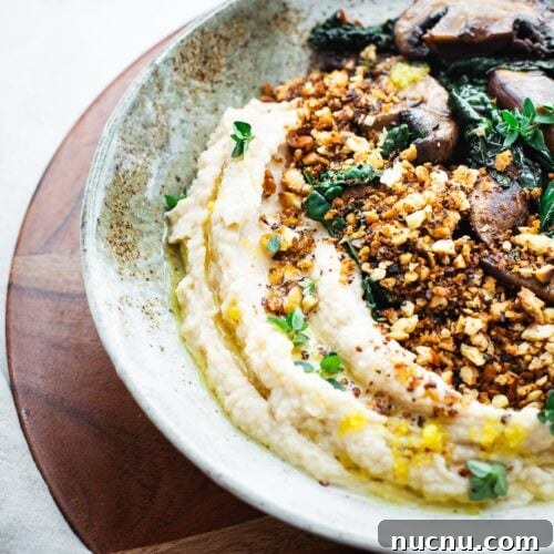 Vegan butter bean mash with sautéed mushrooms and black kale.
