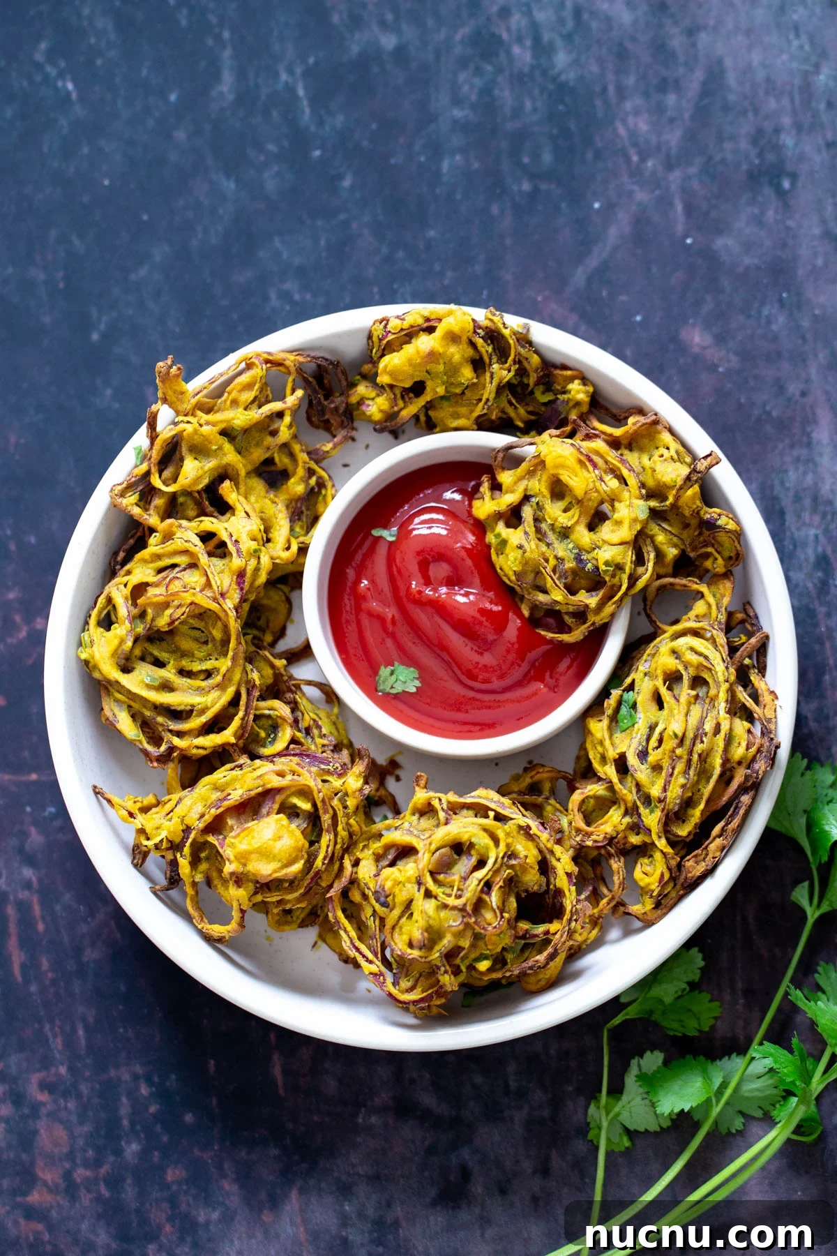 baked pakora overhead shot of baked onion pakora served with ketchup as a dipping sauce