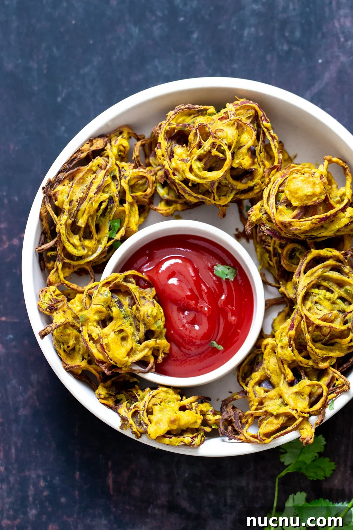 baked pakora a platter with onion pakora served with a small side dish of ketchup