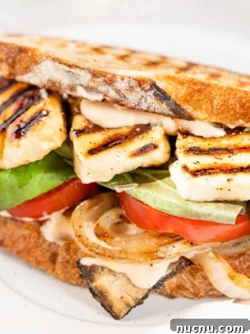halloumi sandwich with grilled bread lettuce and tomato.