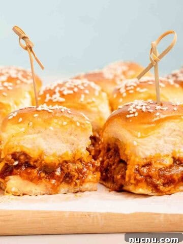 sloppy joe sliders with wooden toothpicks on cutting board.