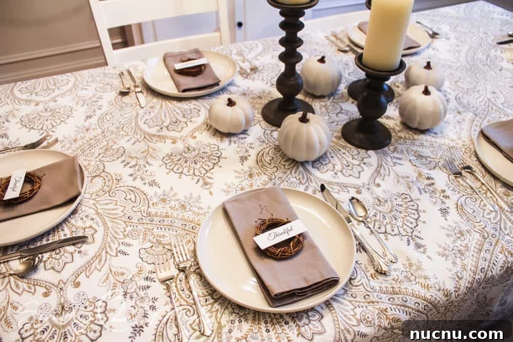 DIY Thanksgiving Place Cards: 3 Stylish Table Setting Ideas 7 view of table set for thanksgiving with candle sticks and mini pumpkins in center