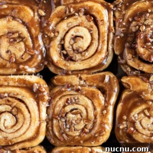 Close up of homemade sticky buns topped with chopped pecans.