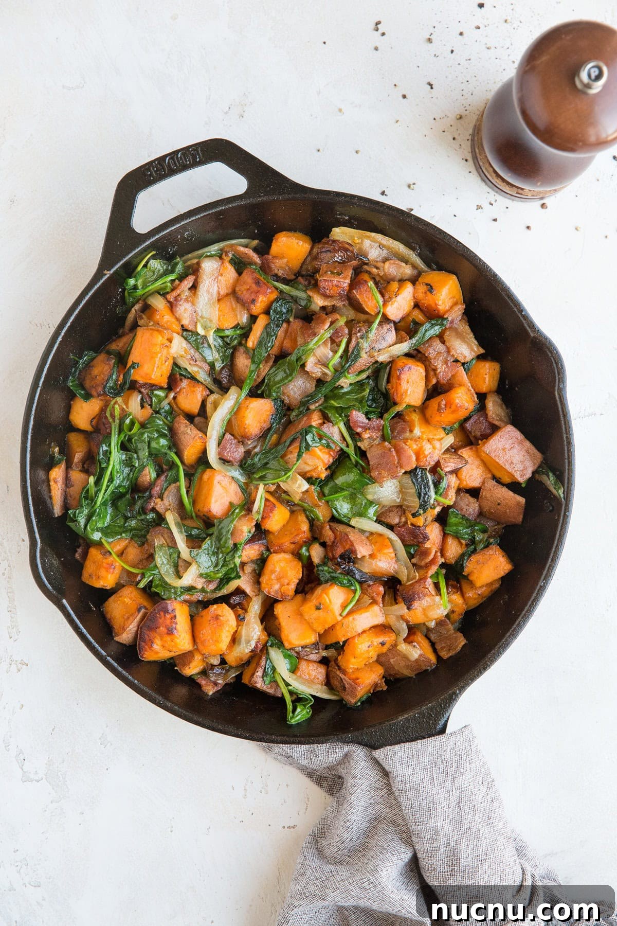 Sweet Potato Hash Recipe with bacon, onion, and spinach. This easy breakfast recipe results in perfectly crispy potatoes