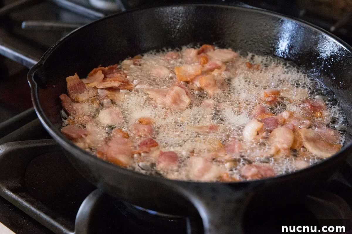 Chop the bacon and cook it in a cast iron skillet until crispy